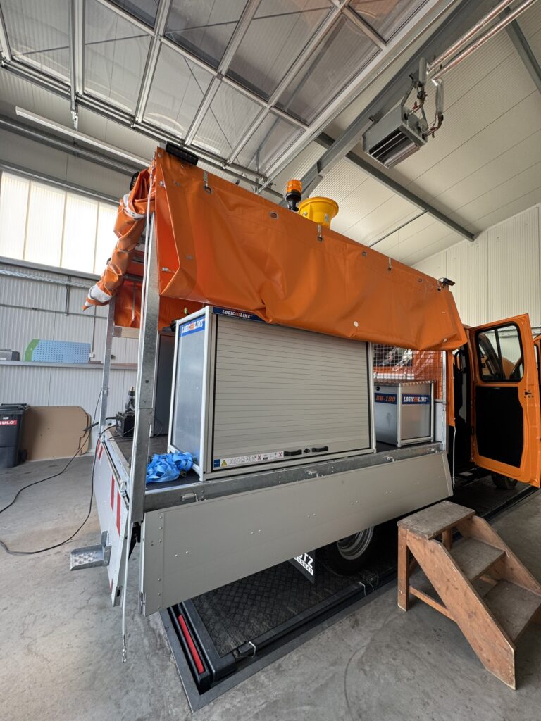 Pritschenfahrzeug mit Rollladen-Staukästen und Markise im Aufbau in der Werkstatt