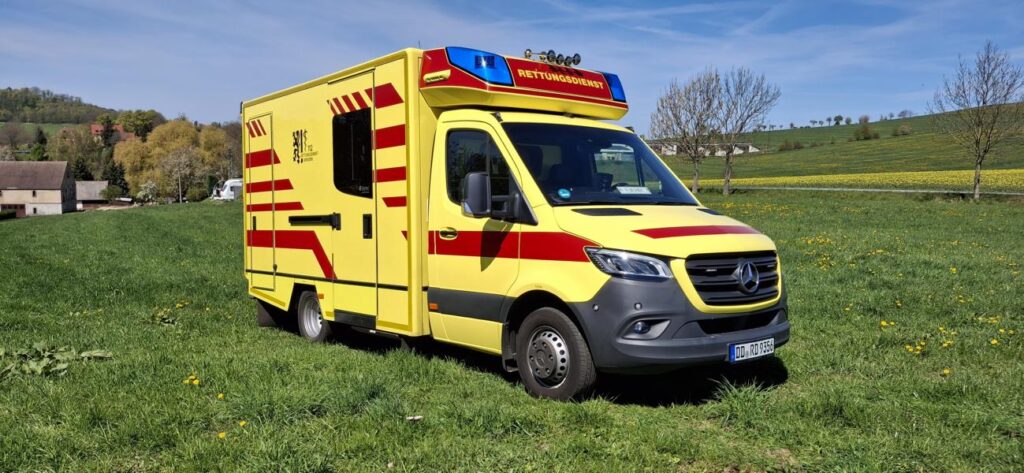 Gelber Rettungswagen auf Mercedes-Sprinter-Basis auf einer Wiese